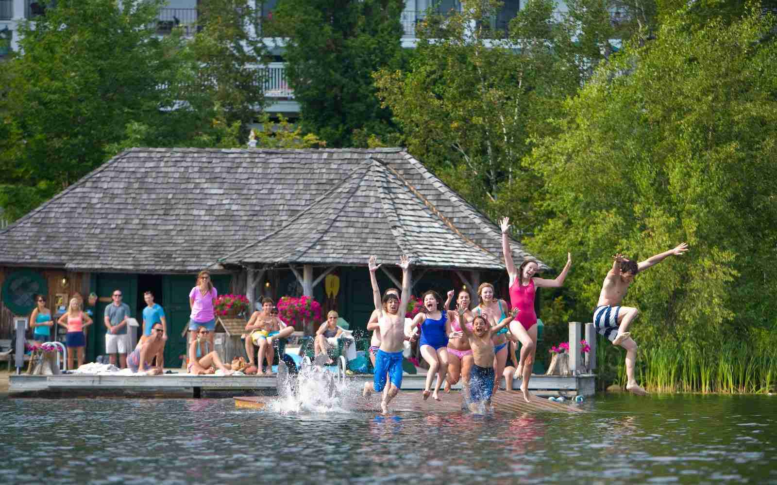 Kids jumping into the lake from a floating dock