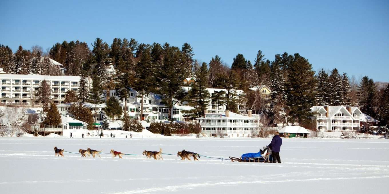 Dog sled moving in front of Mirror Lake Inn.