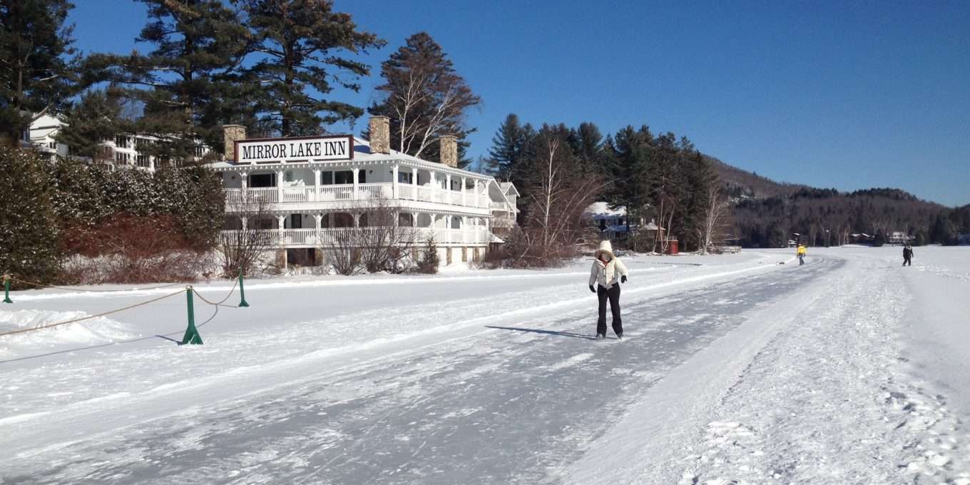 Woman skating solo on lake path in front of hotel