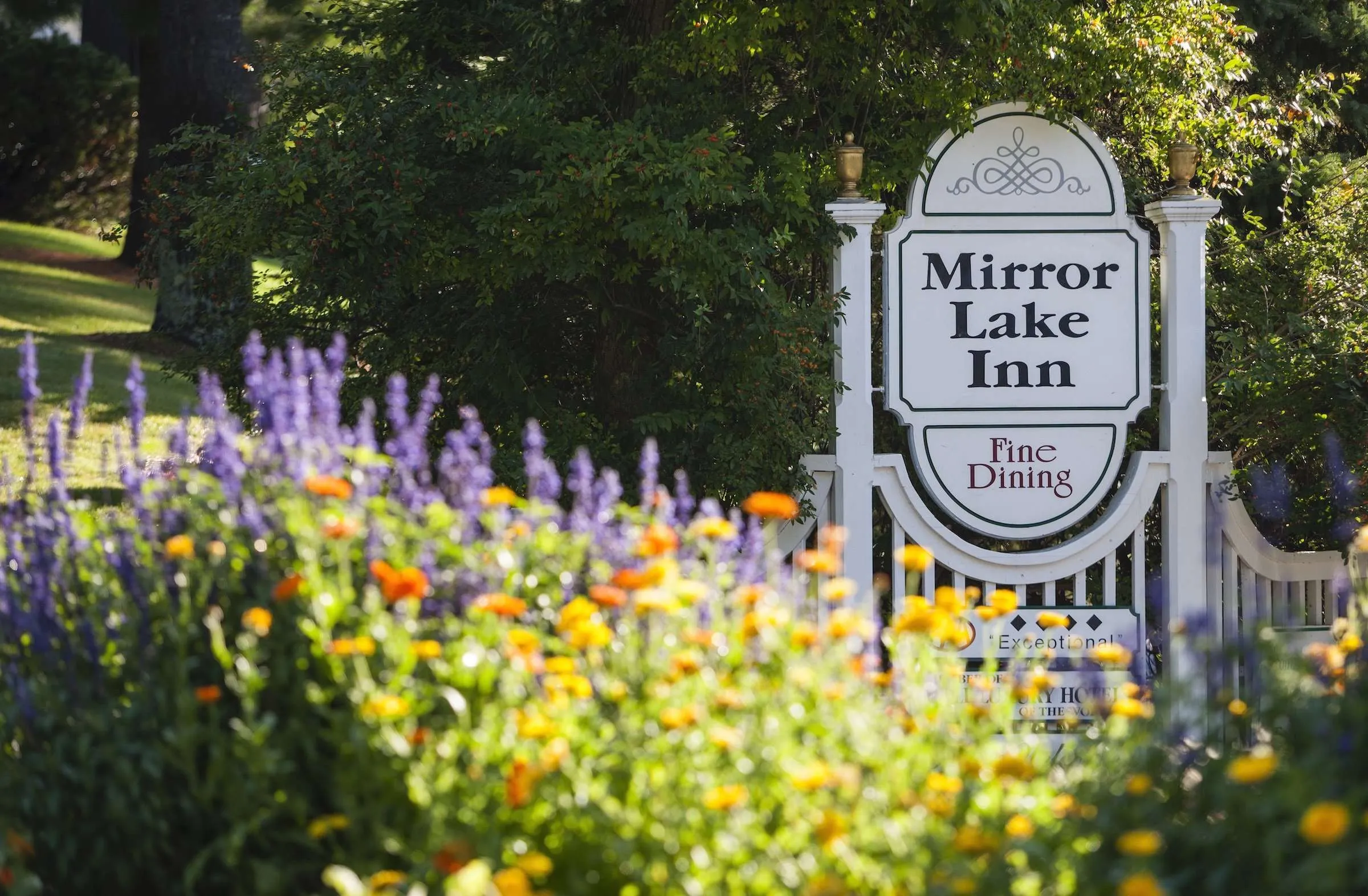 The Mirror Lake Inn signage with lavendar, orange and yellow flowers in the foreground