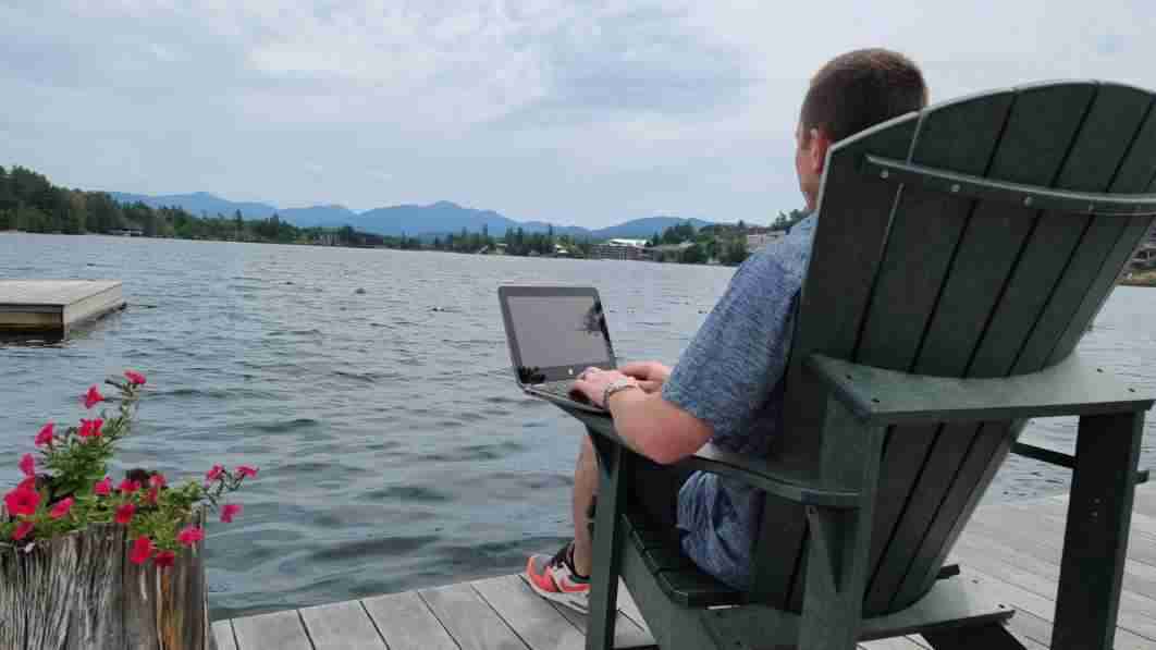 Man on laptop overlooking Mirror Lake