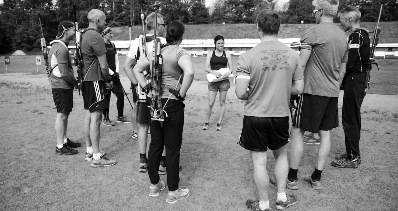 a group of people standing in a circle on a grass land in a black and white photo