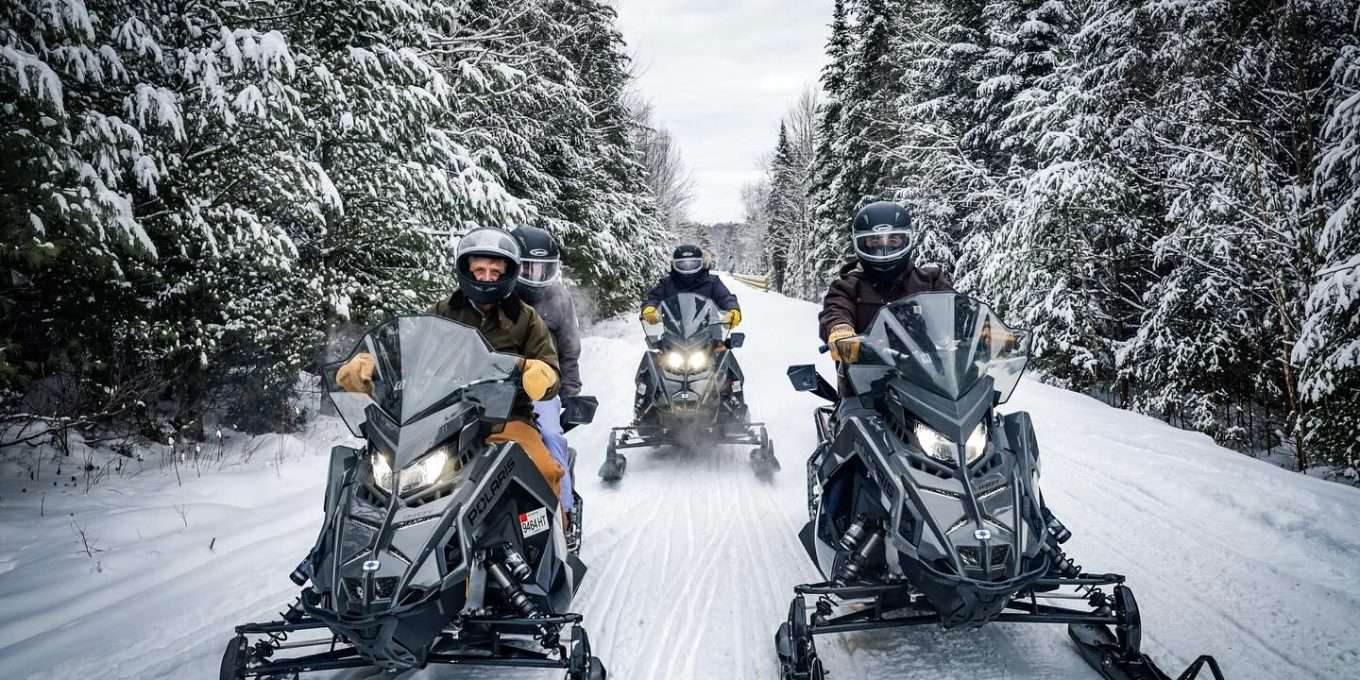 Group snowmobiling on groomed trail
