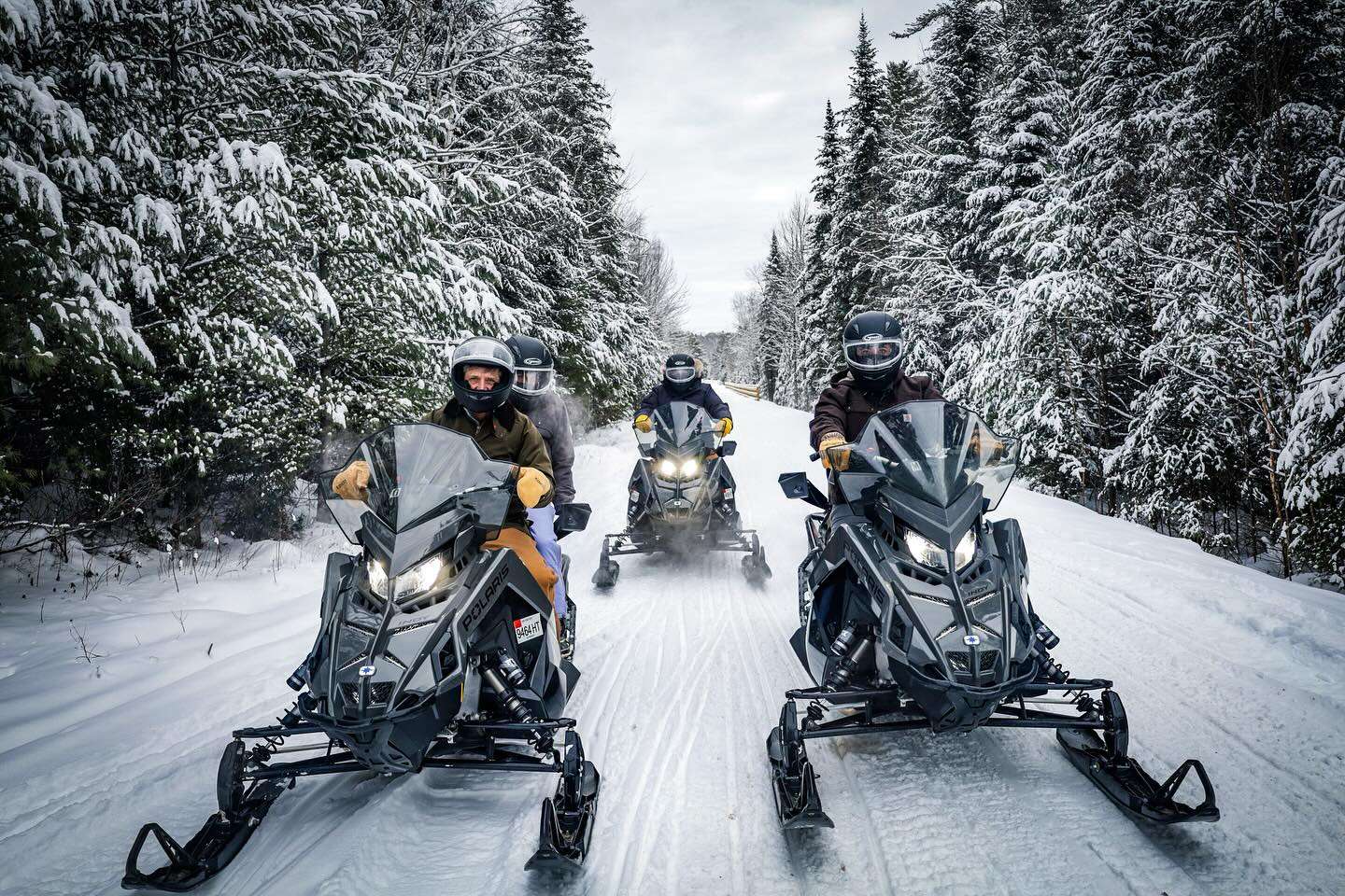 Group snowmobiling on groomed trail